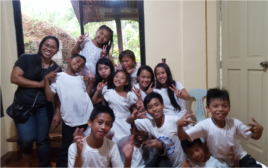 A group of children wearing white tshirt and posing for the camera